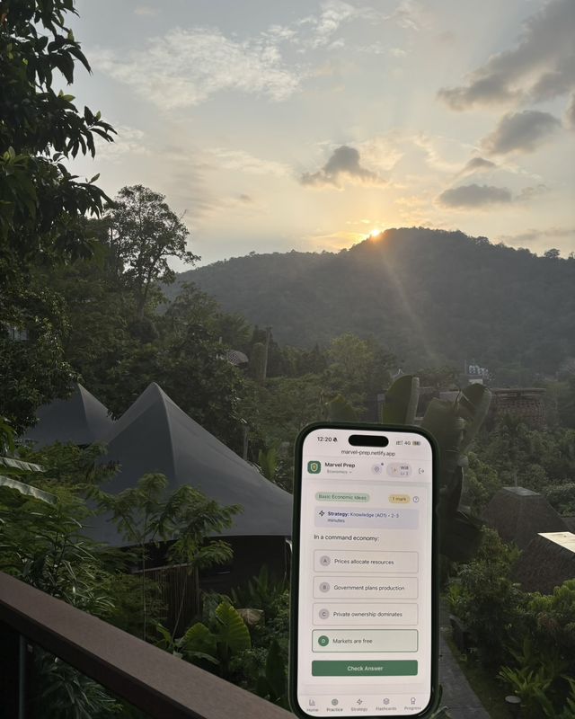 The MarvelPrep app on a phone at sunset over jungle hills